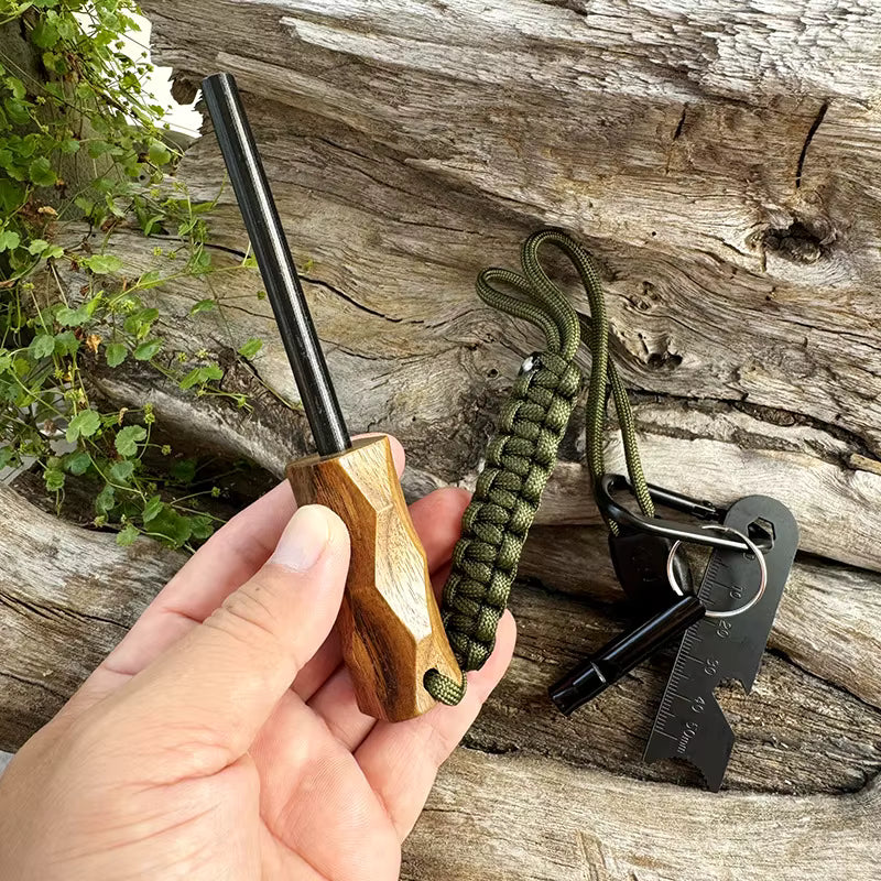 Sparkforge Rod held in hand outdoors against a tree trunk background. Demonstrates ergonomic size, durable construction, and field-ready usability for explorers and survivalists.