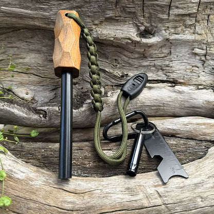 Close-up of Sparkforge Rod and accessories on forest wooden background. Highlights rugged hammer-patterned handle, paracord lanyard, and multi-functional striker with built-in whistle and ruler.